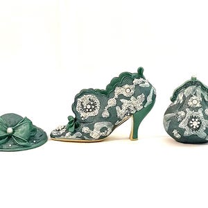 May include: A set of three green and white decorative figurines. The set includes a hat, a shoe, and a purse. Each item is decorated with a floral pattern and white beads.