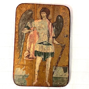 May include: A vintage, hand-painted icon depicting an angel with wings, wearing armour and holding a staff. The icon is painted on a wooden panel with a gold background.