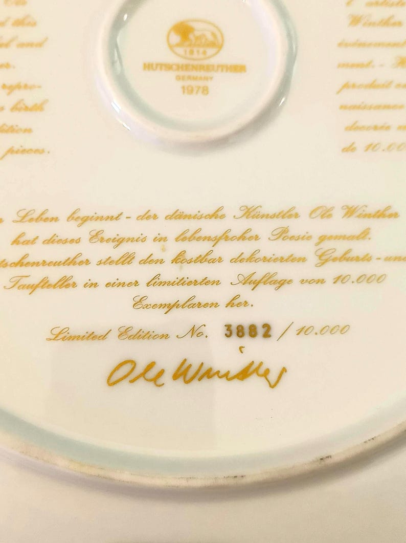 May include: A white porcelain plate featuring gold text and a Hutschenreuther Germany 1978 stamp. The text includes the artist name Ole Winther, a German description, and the limited edition number 3882 out of 10,000. The plate has a smooth finish.