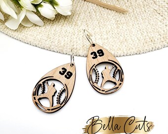 May include: A pair of wooden earrings shaped like baseballs with a baseball player silhouette inside. The earrings are laser cut and have the number "39" on them.