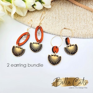Peut inclure: Un ensemble de deux boucles d'oreilles en bois avec un motif de coquillage. Les boucles d'oreilles sont en bois et ont une finition dorée. Les boucles d'oreilles sont vendues en lot et sont parfaites pour ajouter une touche de style à n'importe quelle tenue.