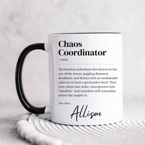 Puede incluir: Taza de cerámica blanca con asa y borde negros. La taza presenta una definición en blanco y negro de "Chaos Coordinator" con el nombre "Allison" en la parte inferior.