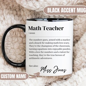 May include: White ceramic mug with a black rim and handle. The mug features a black and white graphic with the text "Math Teacher" and a definition. The text "See also:" is followed by the name "Miss Jones".