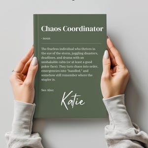 May include: A green book with the text "Chaos Coordinator" and a definition of the term. The book also includes the name "Katie" written in cursive.