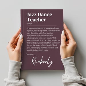 May include: A burgundy book with the text "Jazz Dance Teacher" and a definition of the term. The book also includes the name "Kimberly" in cursive.