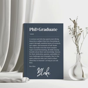 May include: A blue and white printable poster with the text "PhD Graduate" and a definition of the term. The poster also includes the name "Blake" in cursive.