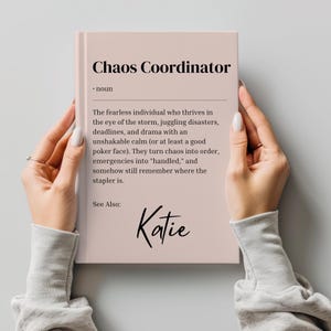 Może przedstawiać: Różowa książka z tytułem "Chaos Coordinator" i definicją tego terminu. Na dole strony widnieje imię "Katie".