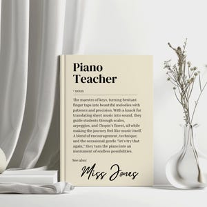 May include: A beige printable wall art print with a black and white definition of a piano teacher. The text reads "The maestro of keys, turning hesitant finger taps into beautiful melodies with patience and precision. With a knack for translating sheet music into sound, they guide students through scales, arpeggios, and Chopin's finest, all while making the journey feel like music itself. A blend of encouragement, technique, and the occasional gentle 'let's try that again,' they turn the piano into an instrument of endless possibilities." The text "See also:" is followed by the name "Miss Jones" in cursive.