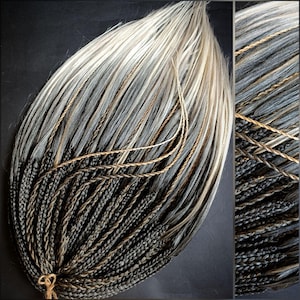 May include: A bundle of synthetic hair extensions in a gradient of colors. The top section is a light, silvery-white, transitioning to gray and then black at the bottom. Thin, brown strands are woven throughout the extensions. Braided sections are visible.