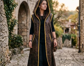 Chaleco largo de cuero con capucha para mujer, hecho a mano, color marrón, de piel de vaca, túnica larga sin mangas, estilo gótico medieval, con ribete amarillo, ideal para cosplay.