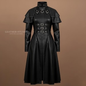 Pode incluir: Casaco longo de couro preto com gola alta, capa nos ombros e cintura ajustada. O casaco apresenta fecho de correr, fivelas decorativas e o texto "LEATHER STUDIO GENUINE LEATHER". A saia é rodada.
