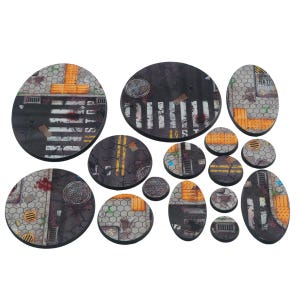 May include: A set of miniature bases depicting urban street scenes. The bases are circular and oval, with details like zebra crossings, drain covers, and road markings. The color scheme includes grey, black, yellow, and orange.