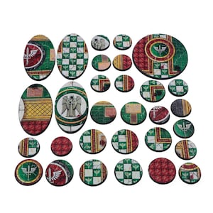May include: A selection of painted miniature bases in various shapes and sizes. The bases feature detailed designs with green, red, and white accents. Some bases have an angel or winged emblem. The bases are for tabletop gaming.