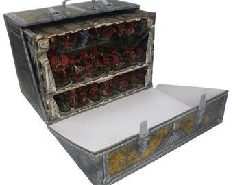 May include: A rectangular storage case with a metallic gray and yellow industrial finish, featuring a top handle and two front latches. The open case reveals two internal shelves filled with numerous small red painted miniature figurines.