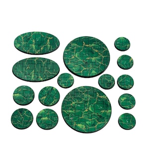 May include: A collection of green and gold-toned, textured bases in various shapes and sizes. The set includes oval and circular bases, each with a brick-like pattern. The bases are designed for miniature figures and tabletop games.