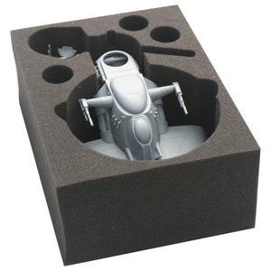 May include: A grey plastic model of a spaceship in a foam insert. The spaceship has a rounded cockpit and two wings with guns.