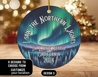 May include: A round, white ceramic ornament with a blue and green aurora borealis design. The text "I saw the Northern Lights in Long Beach, California 2024" is printed on the ornament.