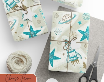 May include: Gift-wrapped presents with a space-themed design featuring rockets, planets, and stars in teal and gold on a cream background. Each package is tied with twine and a white tag. A ball of twine and scissors are also present.