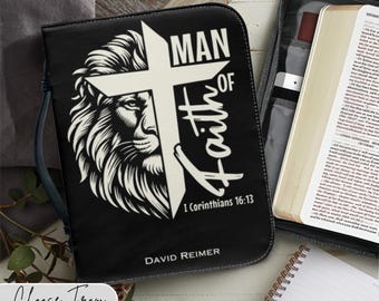 May include: Black leather Bible cover with a white lion head and cross design. The text reads "Man of Faith" and "I Corinthians 16:13". The cover also includes the name "David Reimer".