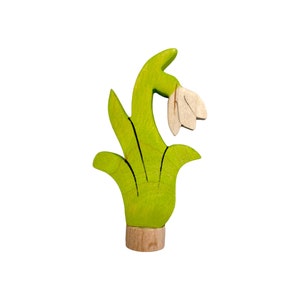 May include: A wooden toy snowdrop flower with green leaves and a white flower. The flower is made of wood and has a natural wood finish.
