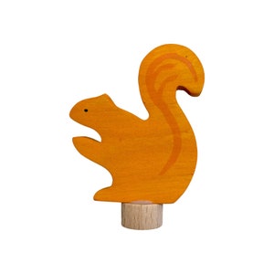 May include: A wooden squirrel figurine with a bushy tail, painted orange with a brown base.