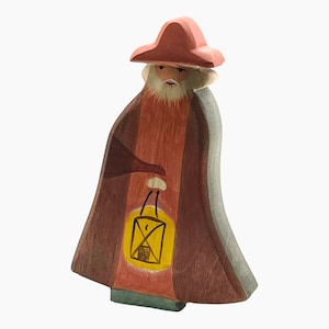 May include: A wooden figurine of a man wearing a red hat and robe, holding a lantern. The figurine is painted in shades of red, brown, and yellow.