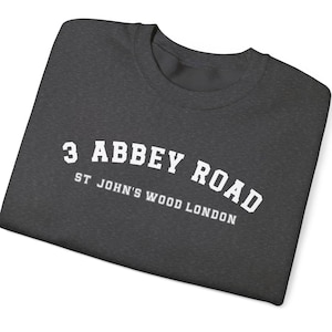 May include: A dark gray t-shirt with white text that reads "3 Abbey Road, St John's Wood London".