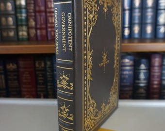 May include: A dark brown leather-bound book with gold lettering and decorative accents. The title is "Omnipotent Government" by Ludwig von Mises.