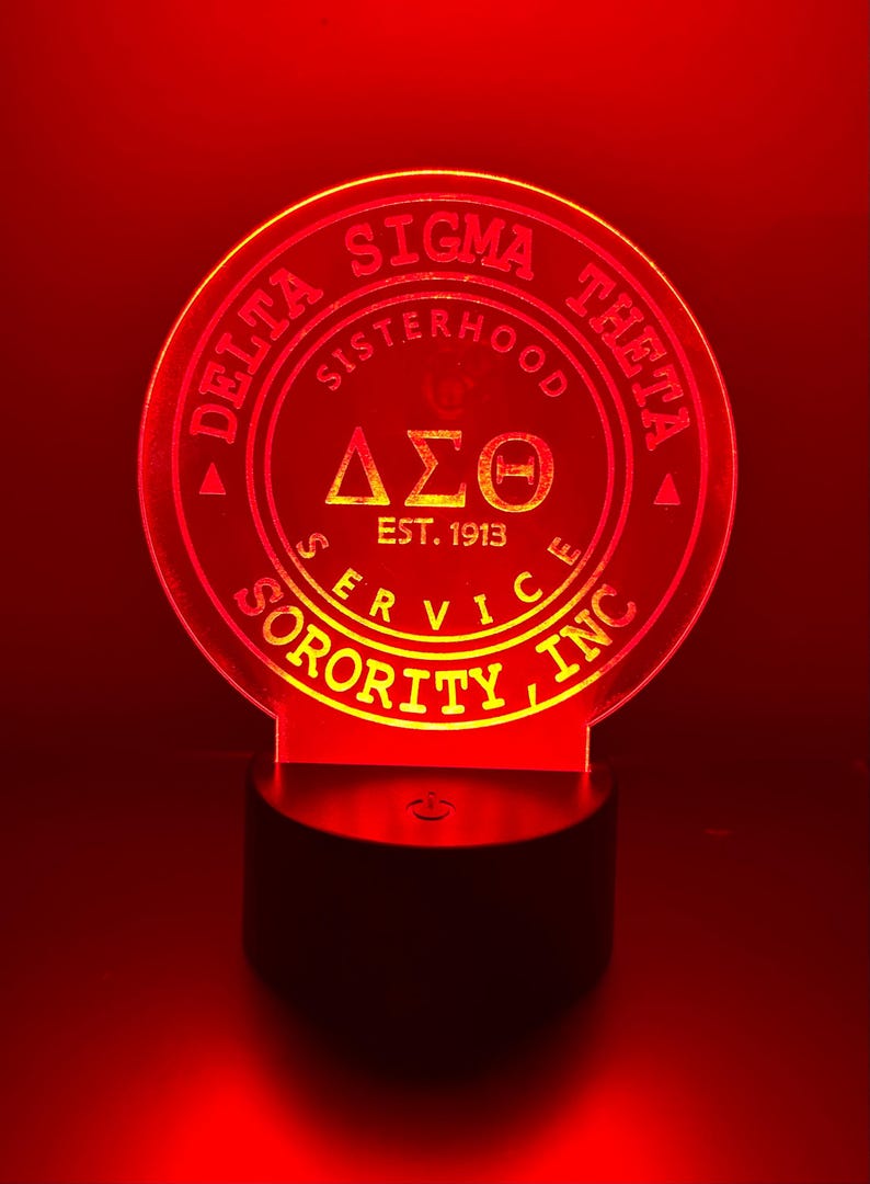 Pode incluir: Uma luz noturna de acr&iacute;lico vermelha e amarela com o texto "Delta Sigma Theta Sorority Inc. Sisterhood Service Est. 1913" e as letras gregas "&Delta;&Sigma;&Theta;" em um c&iacute;rculo.