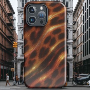 May include: A smartphone case with a brown and gold abstract pattern. The case has a glossy finish and a camera cutout. The background shows a city street with buildings and people.