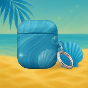 Könnte beinhalten: Eine blaue AirPod-Hülle mit Muscheldesign. Die Hülle hat ein wellenförmiges Muster und einen silbernen Metallring. Eine blaue Muschel befindet sich neben der Hülle auf einem gelben Sandhintergrund mit blauem Ozean und Himmel.