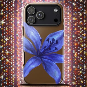 A brown iPhone case displaying a large blue lily illustration is presented vertically against a colorful sparkling bokeh background.