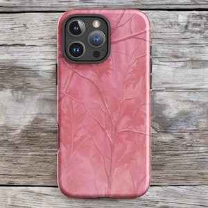 Könnte beinhalten: Eine pinkfarbene Handyhülle mit einem Astmuster. Die Hülle hat eine glänzende Oberfläche und einen Kameraausschnitt. Das Design zeigt ein Netzwerk von Ästen und Blättern in verschiedenen Rosatönen.