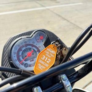 May include: A yellow motel key chain with the text "Lake View Hotel" and the number "312". The key chain also has the text "Toluca Lake Silent Hill".
