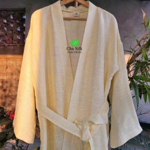 May include: A light yellow silk robe with a tie belt and the text "Chu Silk Simple is the best" on the front.
