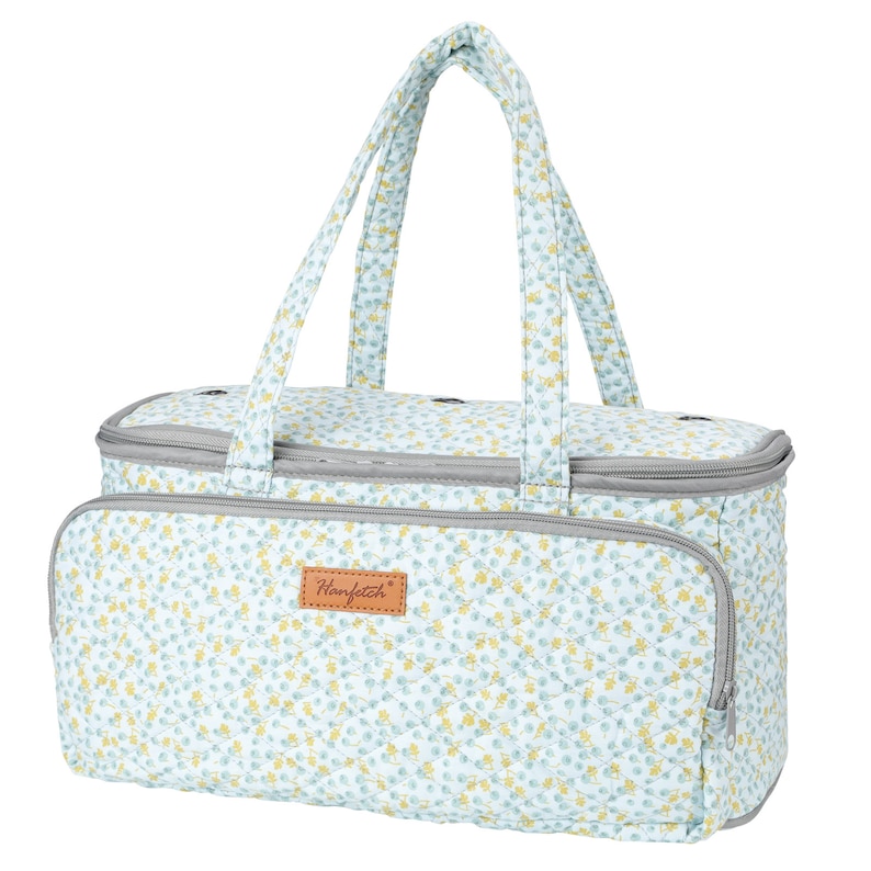 May include: A light blue quilted tote bag with a floral pattern and a brown leather patch that says "Ranfetch". The bag has two top handles and a zipper closure.
