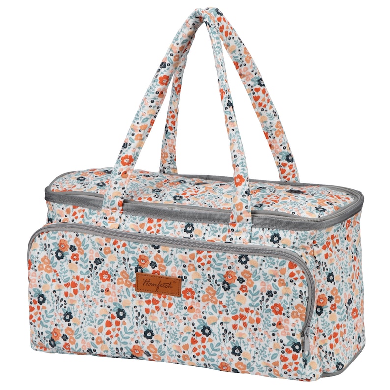 May include: A white fabric tote bag with a floral pattern in shades of orange, blue, and pink. The bag has two gray handles and a brown leather patch with the text "Honfeizhi" on the front.