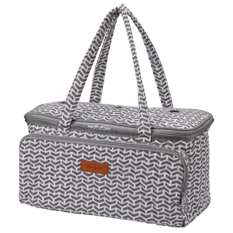 May include: A gray and white chevron patterned insulated tote bag with a brown leather patch that says "Hanfetz".