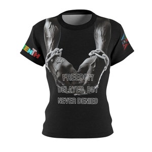 May include: Black t-shirt with a graphic of two muscular arms in chains, with the text "FREEDOM DELAYED, BUT NEVER DENIED" in white. The shirt has a crew neck and short sleeves. The word "SEVENTH" is printed on the left sleeve.