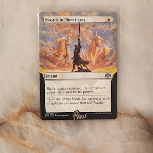 Puede incluir: Una carta coleccionable de Magic: The Gathering titulada Swords to Plowshares, que muestra a una figura sosteniendo una espada en alto frente a un cielo lleno de nubes y bueyes. El texto dice: Exile target creature. Its controller gains life equal to its power.