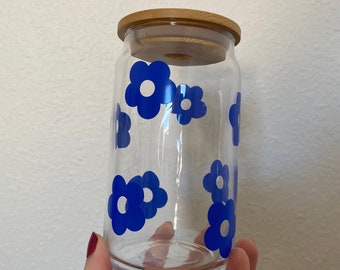 May include: A clear glass jar with a bamboo lid and blue flower decals. The jar is empty.