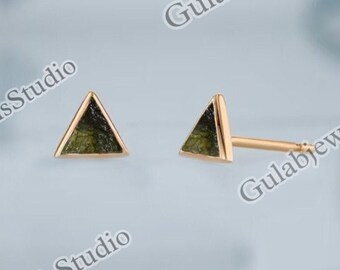 May include: A pair of gold triangle stud earrings with green stone inlays.