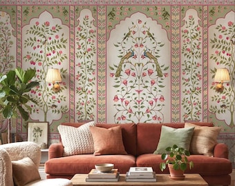 May include: A living room scene featuring a rust-colored sofa, wooden coffee table, and a cream-colored armchair. The wall is adorned with floral wallpaper in shades of green, pink, and white, with a peacock design. A potted plant and lamps complete the cozy setting.