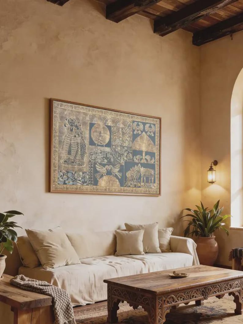 May include: A living room scene featuring a large framed artwork with a blue and gold design above a beige sofa with matching pillows. A wooden coffee table and side table are in front of the sofa. A potted plant and wall sconce add to the room's decor.
