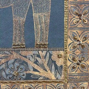 May include: Close-up of a textile with an elephant design. The elephant's legs are detailed with gold thread and sequins against a blue background. The border features floral patterns and gold embellishments, creating a rich, textured look.