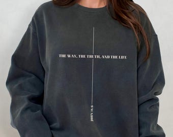 Può includere: Una felpa grigia scura con il testo "THE WAY, THE TRUTH, AND THE LIFE" e "JOHN 14:6" stampato sul davanti.