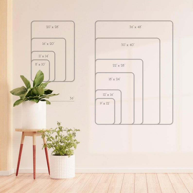 May include: A white wall with a chart of different sizes of picture frames. The chart shows the dimensions of each frame in inches. The chart is on a white wall with a wooden floor. There are two potted plants in the foreground.