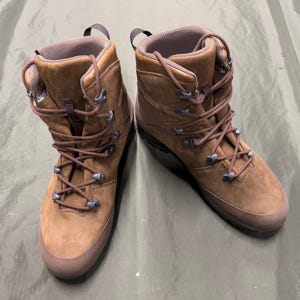 May include: A pair of brown leather hiking boots with brown laces. The boots have a lace-up closure and a rugged outsole.