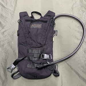 以下が含まれることがあります： 黒いハイドレーションパックで、黒いホースと黒いバックルが付いています。パックには黒いストラップと、前面に「CamelBak」と書かれた黒いロゴが付いています。