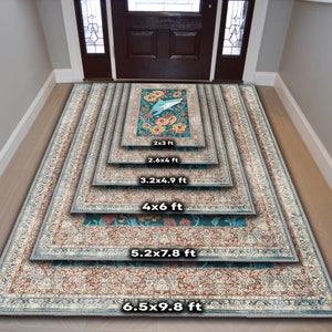 Pu&ograve; includere: Una collezione di tappeti decorativi di varie dimensioni, da 61 cm x 91 cm a 198 cm x 299 cm. Ogni tappeto presenta un design centrale turchese con motivi floreali e di uccelli, incorniciato da un bordo color crema e ruggine con motivi intricati. I tappeti sono esposti in un corridoio.